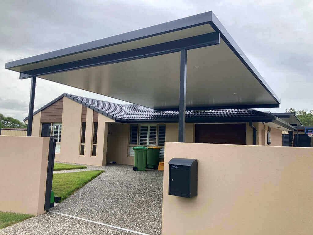 Stylish insulated flyover patio carport supported by two posts, blending seamlessly with the existing house architecture.