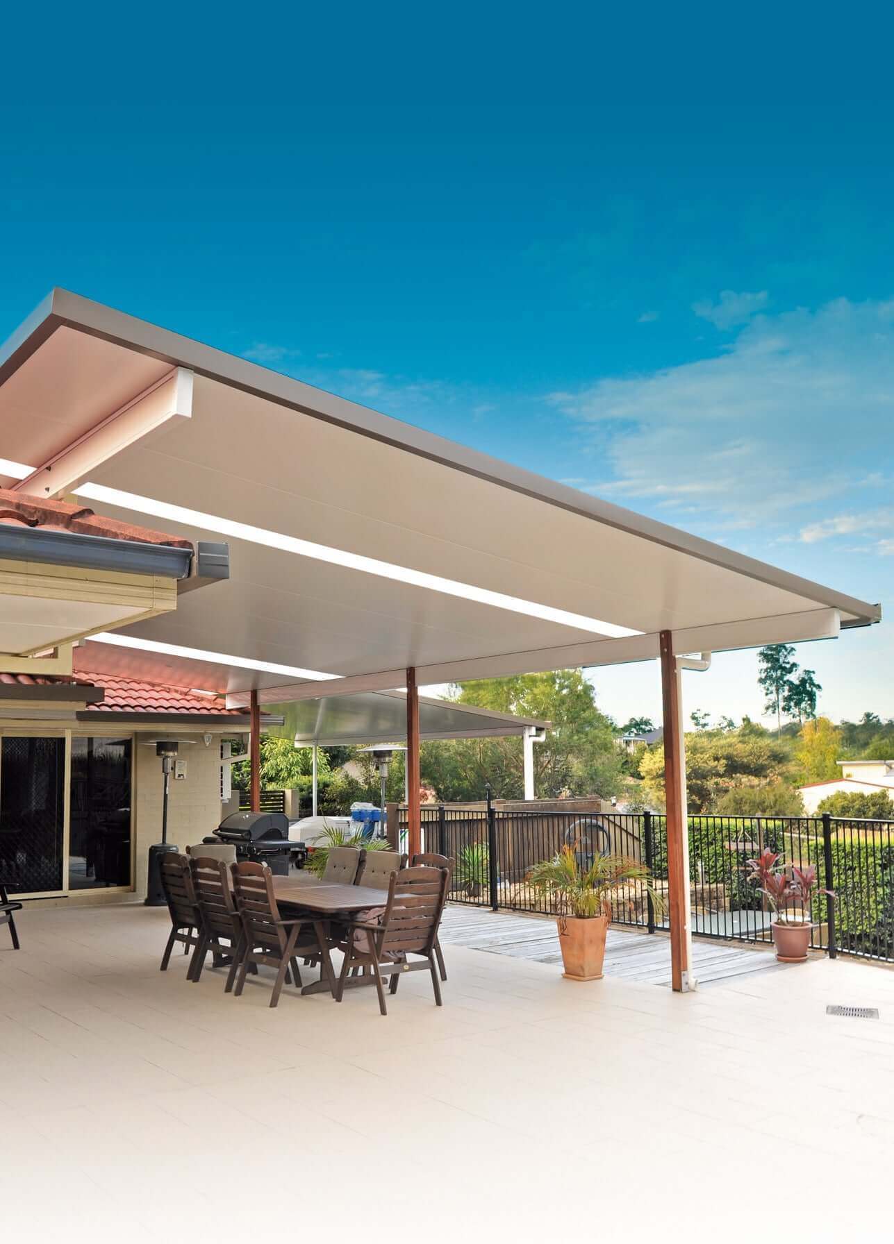 Insulated patio with extended roofline and outdoor dining setup, offering a versatile covered entertaining area overlooking the garden.