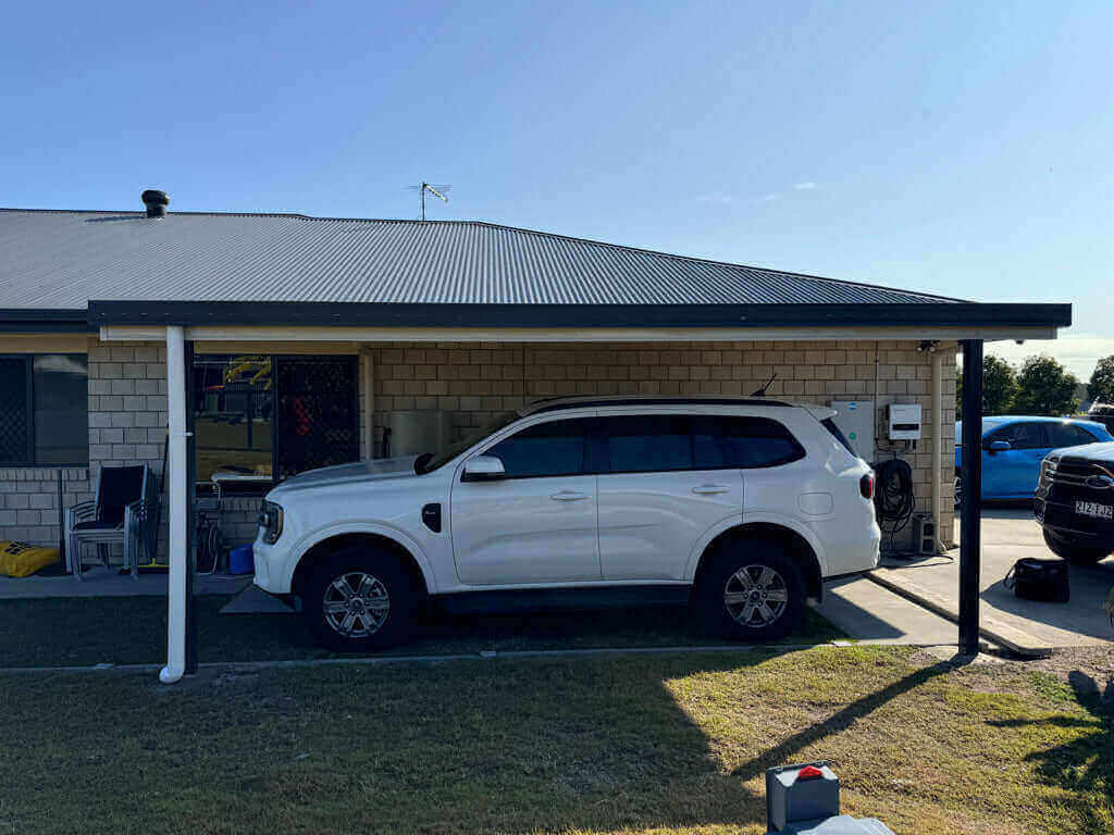 Single skin V-Line carport with a flat roof profile, attached to the home and supported by steel posts, providing a durable, low-maintenance carport solution that offers excellent vehicle protection, clean architectural lines, and a modern driveway upgrade suited to Australian conditions.