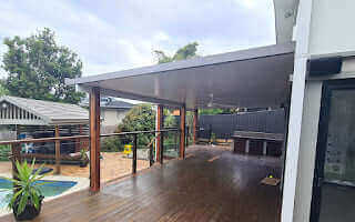 Insulated patio roof attached to a residential deck, offering weather-resistant coverage for outdoor living areas.