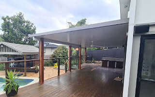Attached insulated patio with timber posts and flyover-style roof, creating an elegant outdoor entertaining and shaded car space.