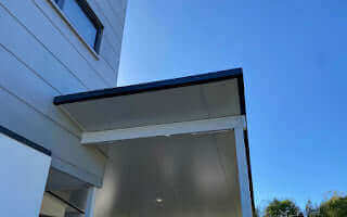 Modern insulated carport attached to a residential home, providing sheltered parking and year-round weather protection.