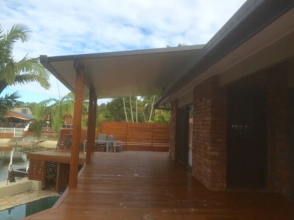 Attached insulated patio with wooden deck, designed for outdoor shelter and comfort, overlooking a serene water view.