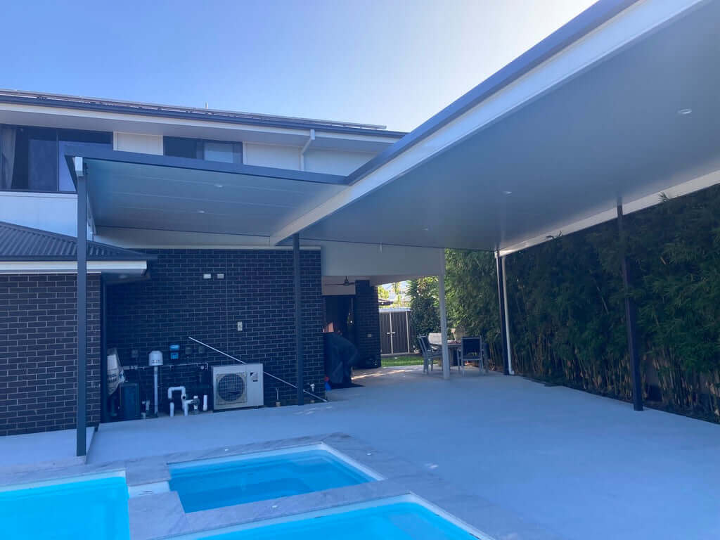 Modern insulated patio carport near the pool, designed for shade and style, ideal for leisure, socializing, and enjoying the backyard oasis.