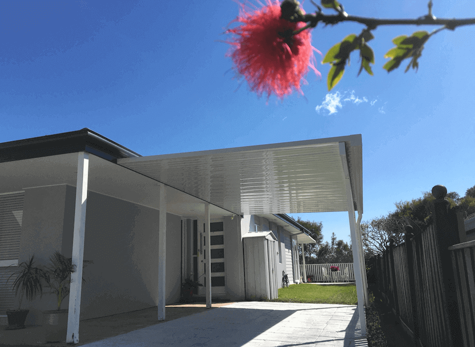 Contemporary single skin carport/patio attached to a residential wall, extending the outdoor living area with a simple and durable steel roof.