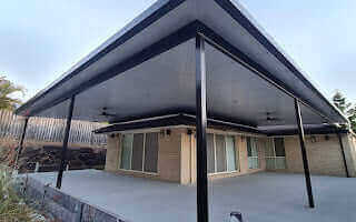 Stylish insulated flyover patio positioned in the corner, finished in sleek ebony, providing a shaded and inviting outdoor area.