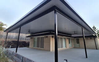 Stylish corner flyover patio with ebony insulated roofing, creating a comfortable, visually appealing space for family and guests.