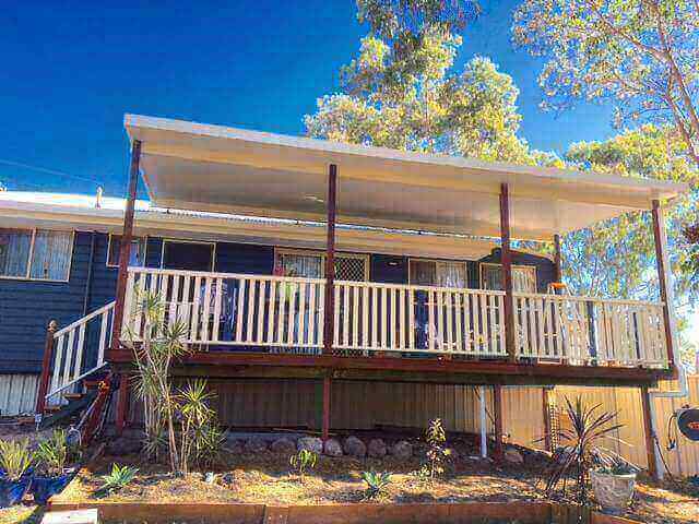 Flyover insulated patio with timber deck, nestled in serene countryside surroundings for ultimate outdoor relaxation.