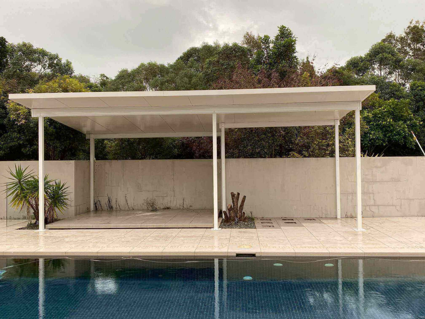 Freestanding insulated patio carport located in the pool area, perfectly complementing the surroundings and highlighting the sparkling blue pool for a cohesive and stunning outdoor space.