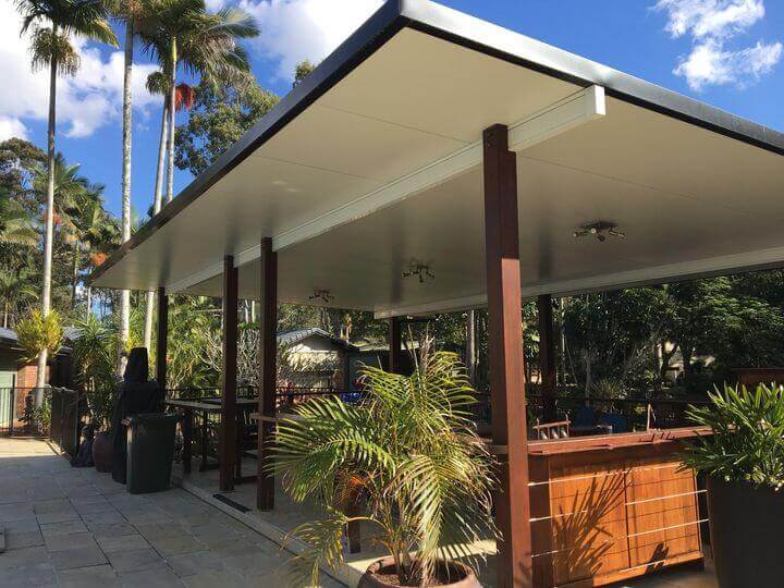 Freestanding patio carport gracefully positioned near the pool, featuring elegant merbau posts and stylish finishes that create a striking, eye-catching outdoor retreat.