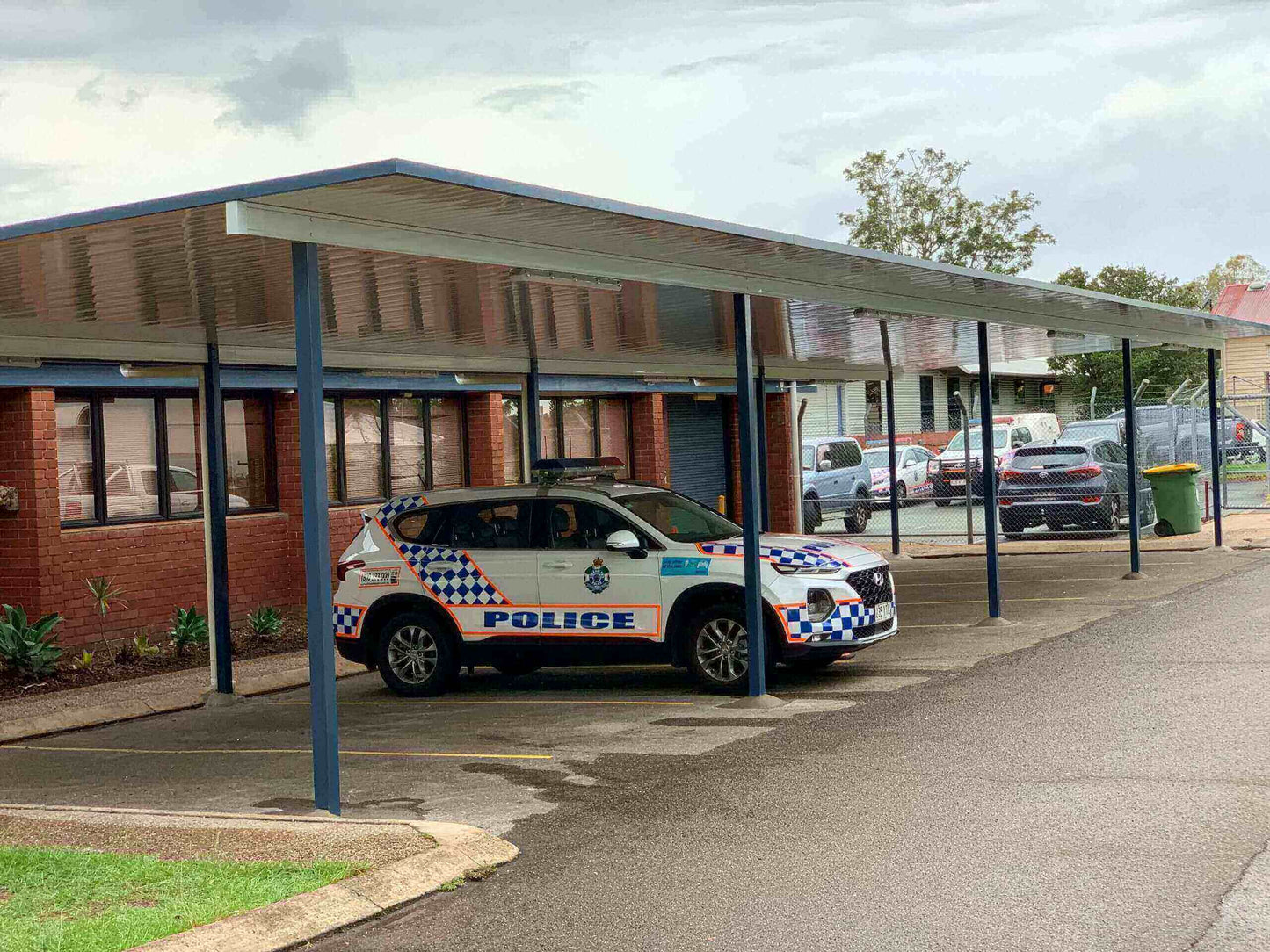 V-Line single skin free standing patio/carport installed in a commercial police station setting, providing reliable weather protection for fleet vehicles.