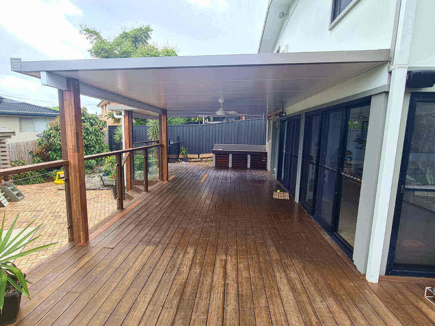 Spacious insulated patio attached to a modern home, creating a covered timber deck area ideal for entertaining and poolside relaxation.