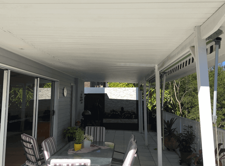Attached single skin patio carport extension providing a covered alfresco space with outdoor dining area and sliding door access.