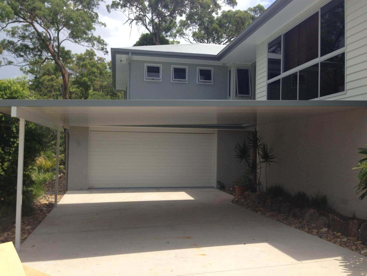 Insulated patio carport with a modern design providing shade and protection for vehicles.