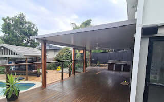 Spacious insulated patio with timber posts overlooking a pool area, ideal for relaxing and entertaining.