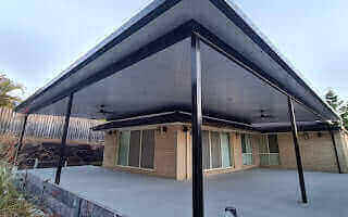 Elegant corner flyover patio with ebony insulated roof, designed to provide a comfortable and visually inviting outdoor space for family and guests.