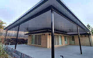 Elegant corner flyover patio with ebony insulated roof, designed to provide a comfortable and visually inviting outdoor space for family and guests.
