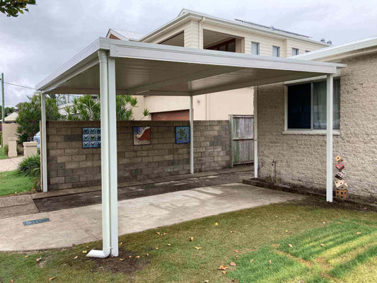 Free standing single skin patio carport set along the boundary, complemented by a retaining wall for a clean and practical outdoor design.