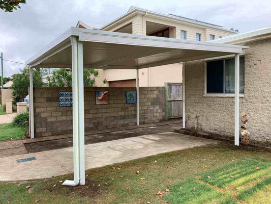 Single-skin free-standing patio/carport strategically positioned near a boundary and retaining wall, offering a seamless, functional design with durable construction, stylish aesthetics, and a versatile outdoor space for relaxation or entertaining.