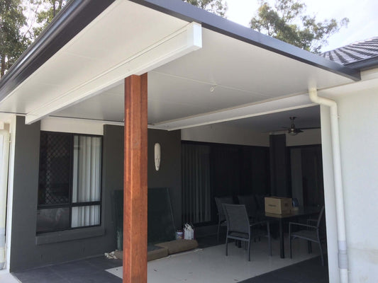 Insulated patio roof attached to a modern home with timber support posts, creating a stylish covered outdoor entertaining area.