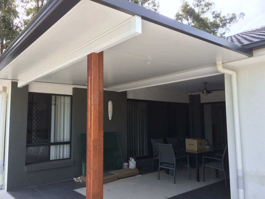 Insulated patio roof attached to a modern home with timber support posts, creating a stylish covered outdoor entertaining area.
