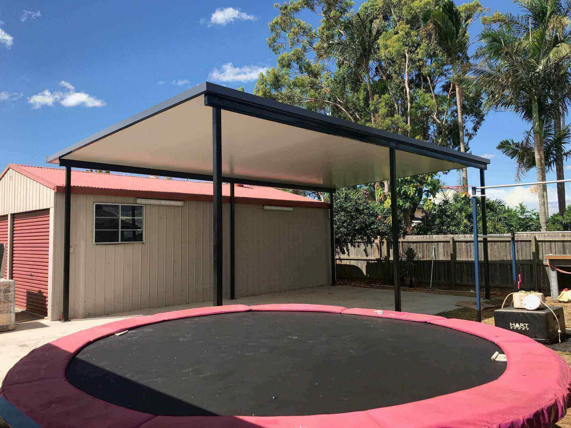 Single Skin free standing patio or carport perfectly situated beside the storage garage and seamlessly adjoining the outdoor play zone with trampoline.