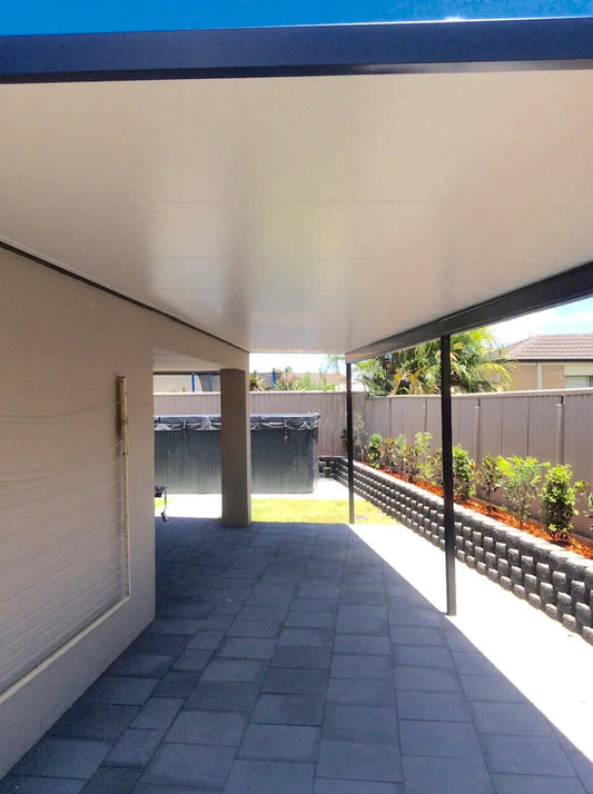 Insulated carport attached to a residential property, offering shaded parking space and protection from sun and rain.