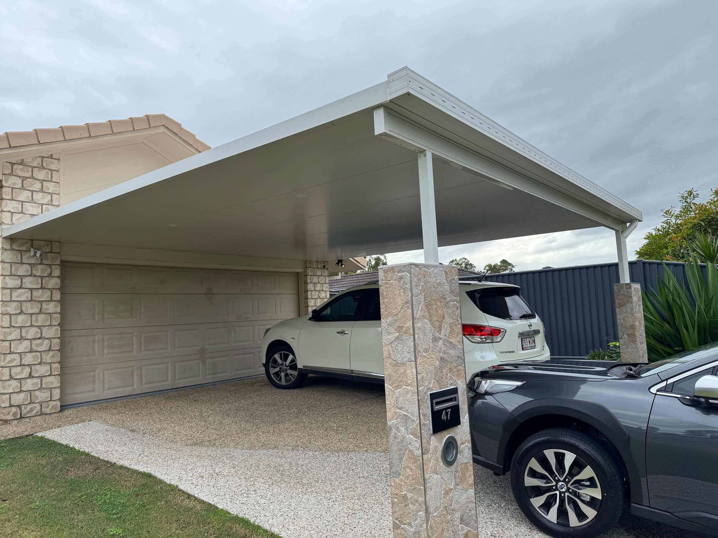 Insulated double carport with sleek design offering secure and weatherproof vehicle protection.