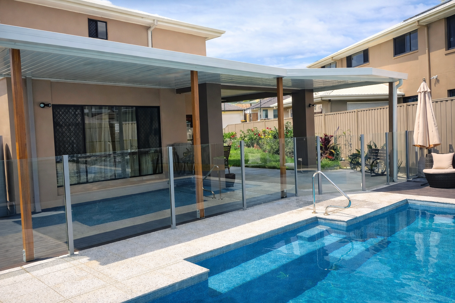 Modern flat, single-skin patio roof with white metal panels fixed on the house over an outdoor entertaining area, supported by timber posts and providing shaded coverage beside a swimming pool.