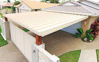 Single skin patio roof attached to a house wall, providing shaded outdoor space with a simple and durable steel design.