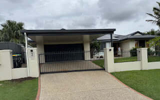 Modern single skin patio carport attached to a contemporary home with rendered fence and landscaped front yard.