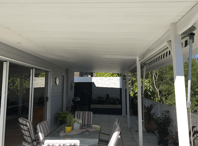 Attached single skin patio extension providing a covered alfresco space with outdoor dining area and sliding door access.