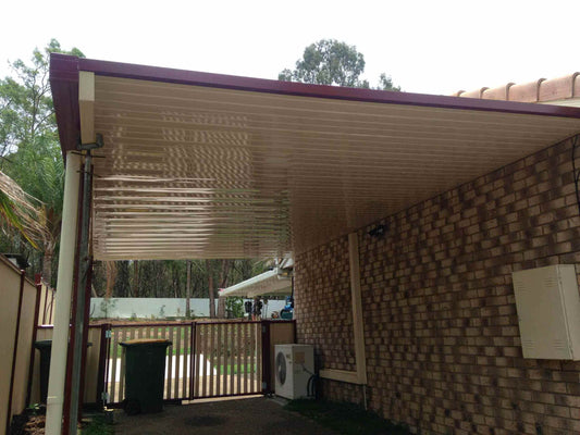 Durable single skin patio roof extension attached to a brick home, providing weather protection for driveway or garden area.
