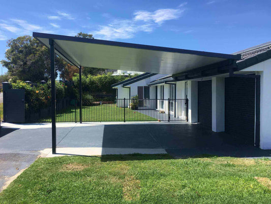 Minimalist insulated carport fixed to a modern house, providing shaded vehicle parking and protection from the elements.
