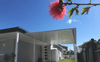 Contemporary single skin carport/patio attached to a residential wall, extending the outdoor living area with a simple and durable steel roof.